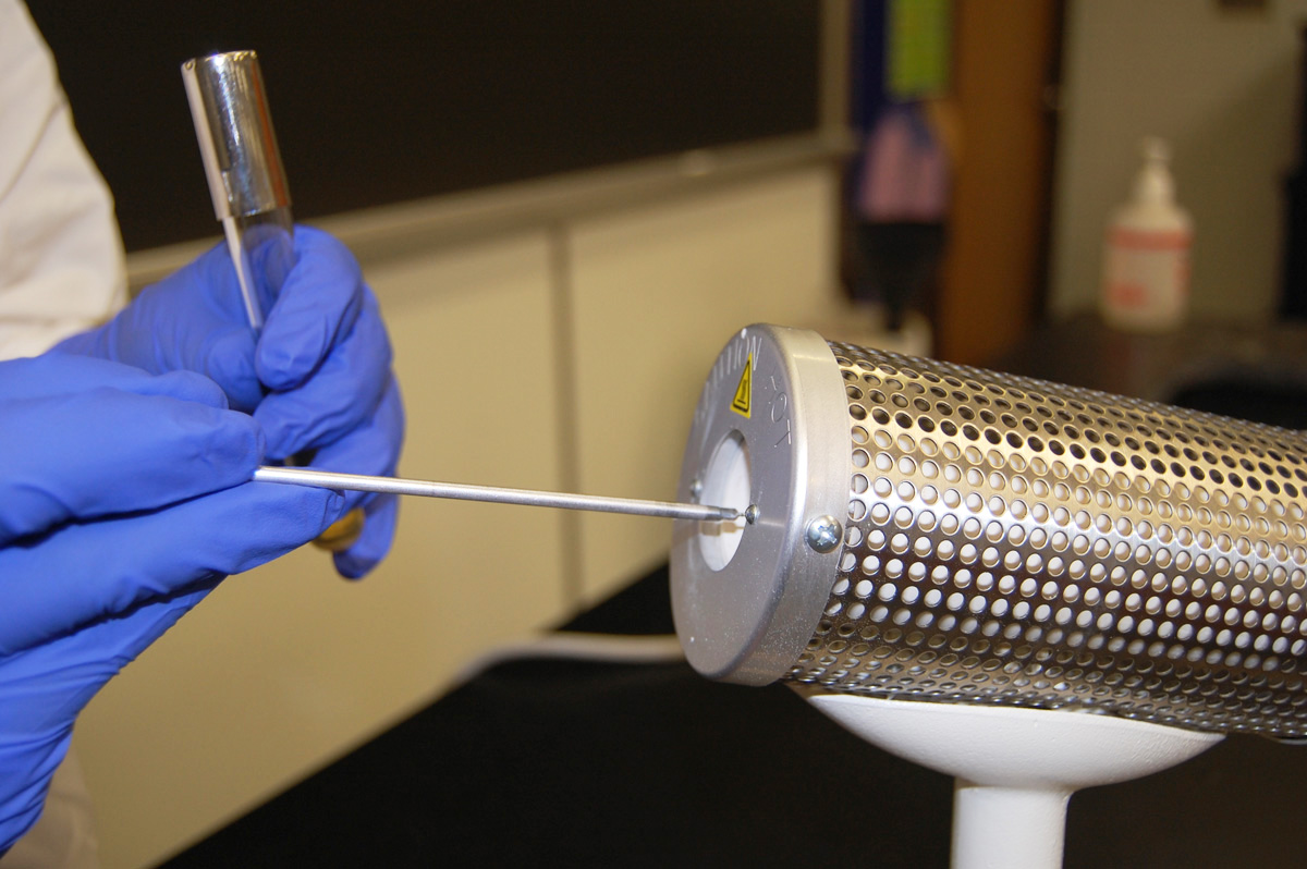 Photograph showing how to sterilize the inoculating loop in a microincinerator.